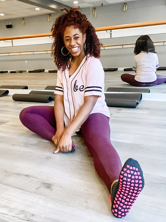 Barre instructor stretching in front of ballet bar before class