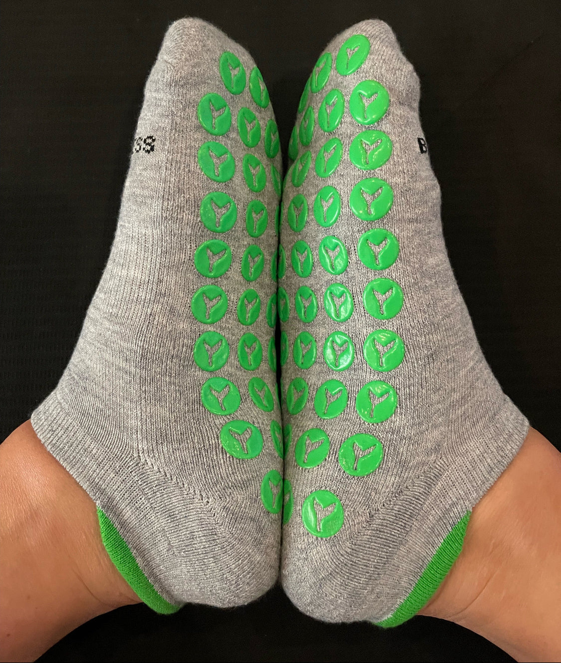 Heather gray socks with green textured grippy sole and green heel tab